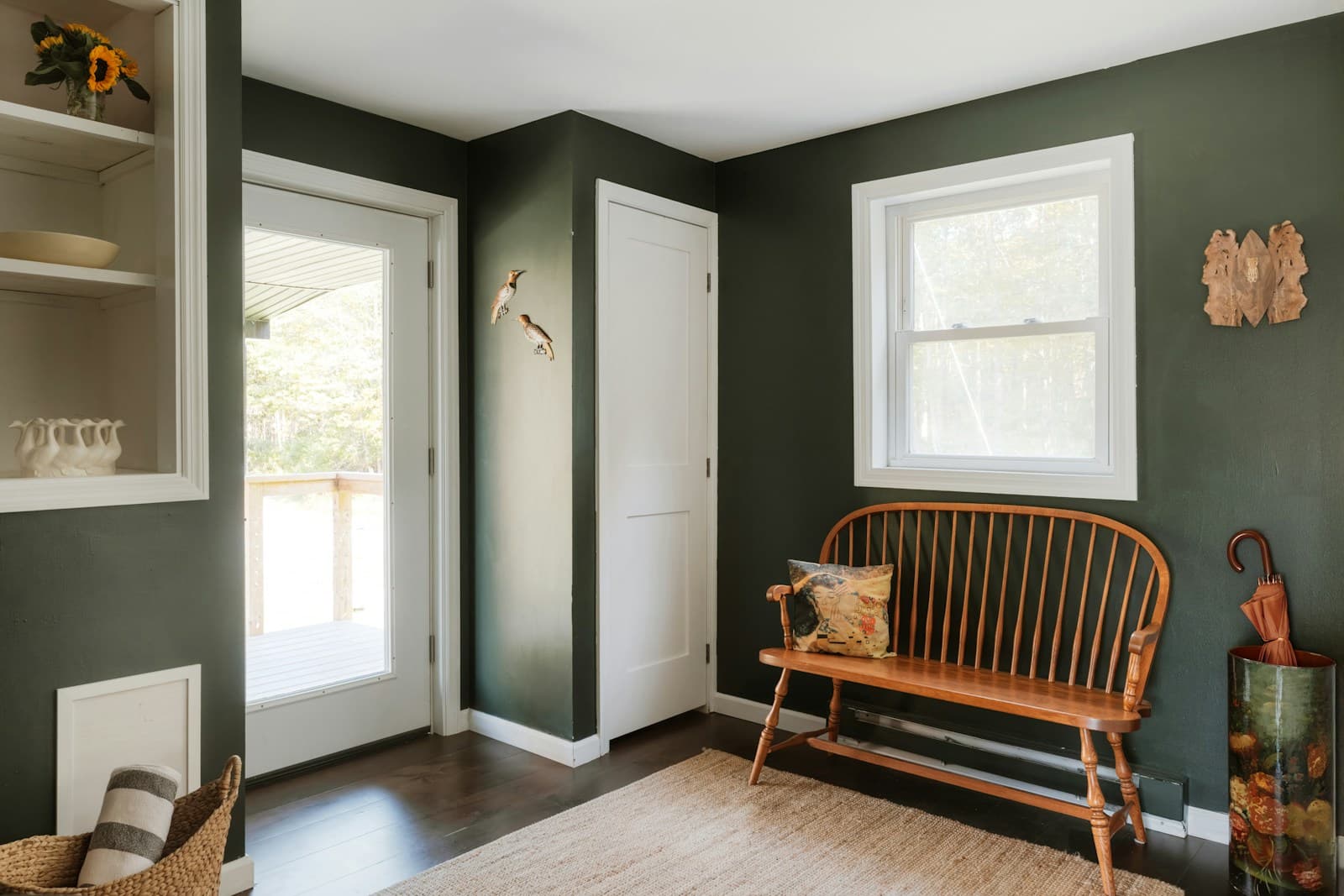 Green entryway with a bench and storage shelves