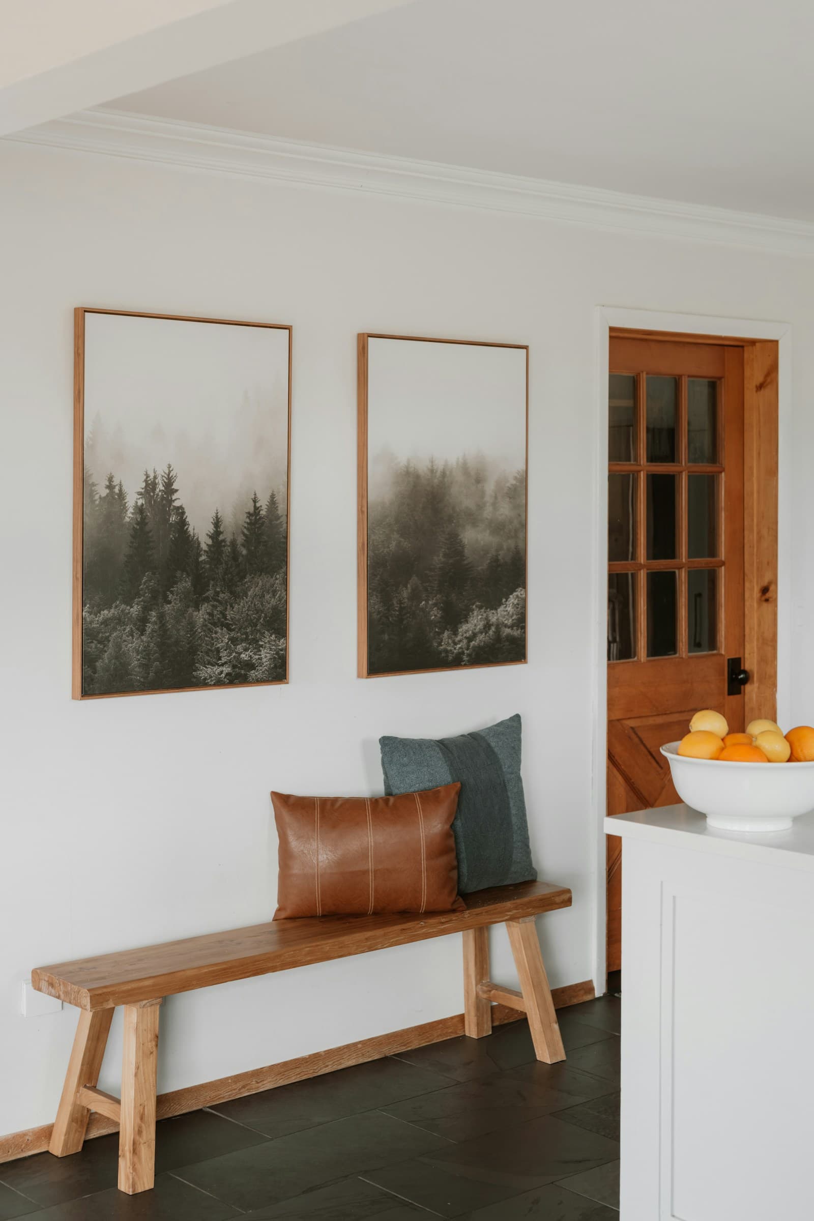 A welcoming wood bench with cushions in a bright entryway