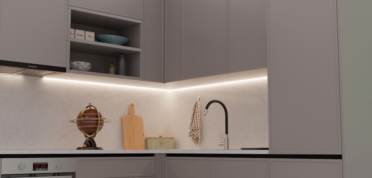 Grey corner cabinetry with aligned doors and under-cabinet lighting