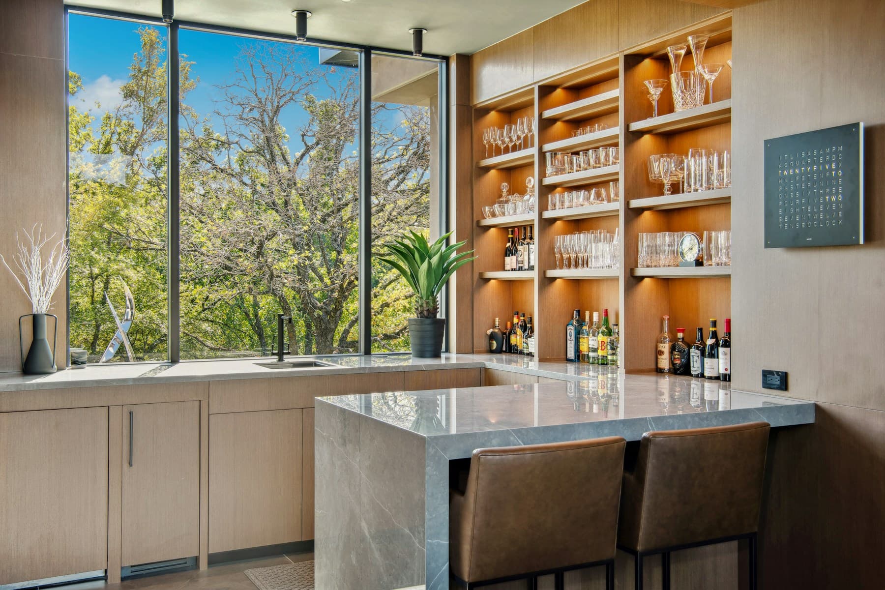 Wood home bar with glassware storage and a large window